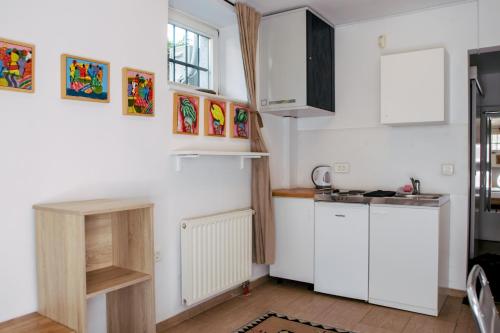 a kitchen with white cabinets and a sink at Budget dbl Studio free breakfast in Ljubljana