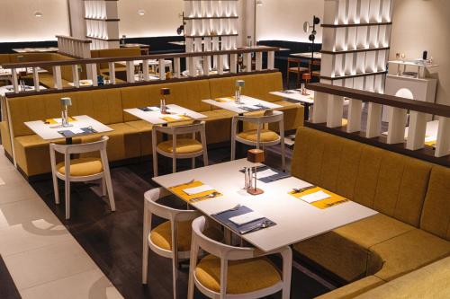 a dining room with tables and chairs in a restaurant at voco Seoul Gangnam by IHG in Seoul
