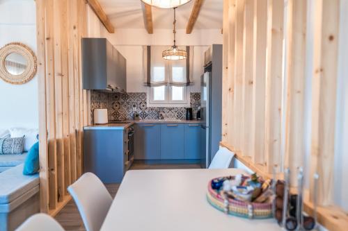 cocina con paredes de madera, mesa y sillas en Epithea Suites Kythnos 5 με ιδιωτική πισίνα en Kíthnos