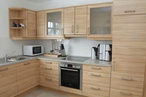 a kitchen with wooden cabinets and a stove top oven at Ferienhaus Inselliebe in Borkum