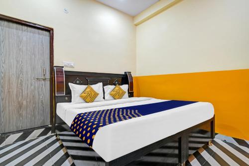 um quarto com uma cama amarela e azul em SPOT ON 81125 Hotel Ashirwad em Indore