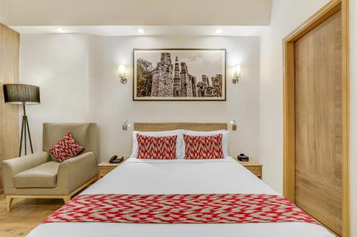 a hotel room with a bed and a chair at Lemon Tree Premier 1, Gurugram in Gurgaon