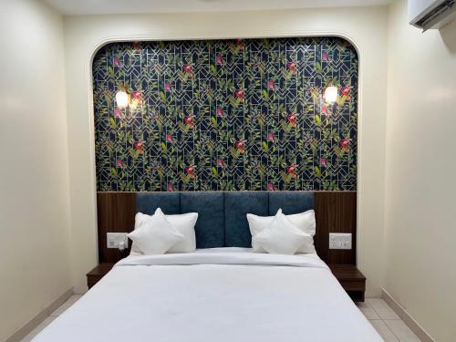 a bedroom with a large bed with a floral headboard at The Blue Vista in Greater Noida