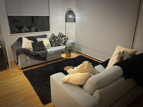 a living room with a white couch and a table at Flat Bush Holiday Accomodation in Auckland