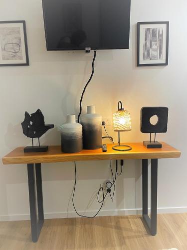 a wooden table with vases and a television on top at Flat Bush Holiday Accomodation in Auckland