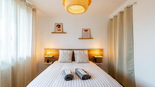 une chambre avec un lit avec deux serviettes dessus dans l'établissement L Appart de Lilou : Paisible / Confort /Proche Centre Ville, à Dijon