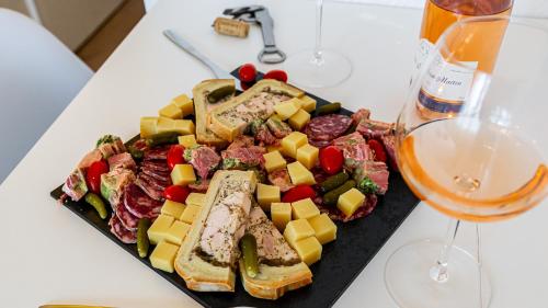 une assiette de nourriture à côté d'un verre de vin dans l'établissement L Appart de Lilou : Paisible / Confort /Proche Centre Ville, à Dijon
