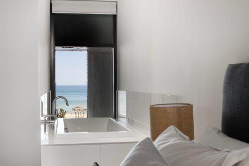 a bathroom with a sink and a view of the ocean at The Sandpiper Sanctuary at Henley Beach in Henley Beach South