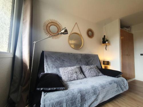 - une chambre avec un lit doté d'un miroir et d'une lampe dans l'établissement Résidence Le Cairn - Agréable studio 4 personnes au coeur des Orres MAE-6471, aux Orres