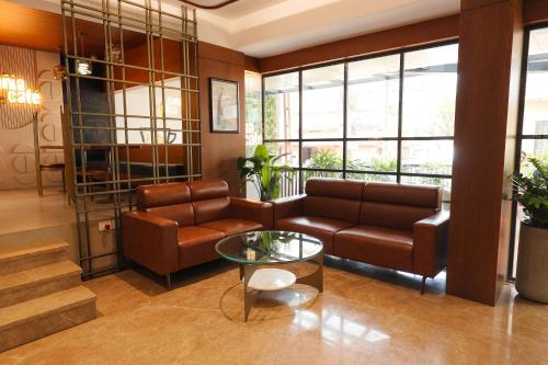 a living room with a couch and a table at Hotel Blue Bell in Kozhikode