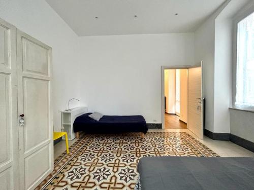 Habitación con dormitorio con cama y puerta en aCàToa - spacious bright apartment in the city center 3 bedrooms - La Spezia / easy access and connections to 5 Terre and Portovenere, en La Spezia