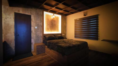 a bedroom with a bed and a window in a room at Mistil Garden Resort in Kozhikode