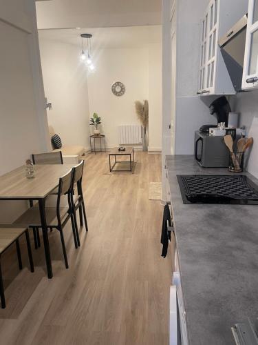 une cuisine et une salle à manger avec une table et une cuisine et une salle à manger dans l'établissement Appartement authentique coeur de ville sete, à Sète