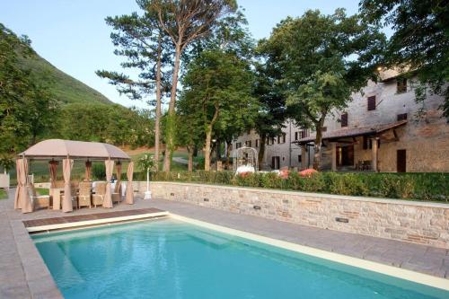 una piscina con cenador y una casa en Ferienhaus für 20 Personen in Gubbio-Nerbisci, Ubrien Provinz Perugia, en Mocaiana