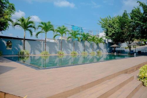 een zwembad in een resort met palmbomen bij Canterbury Apartments - Kahathuduwa Gonapola in Gonapola