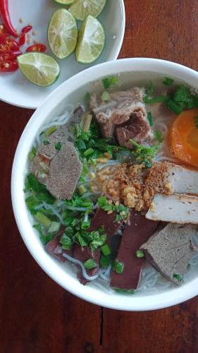 una ciotola di zuppa con carne e verdure su un tavolo di Lucky Phu Quoc Hotel a Phu Quoc