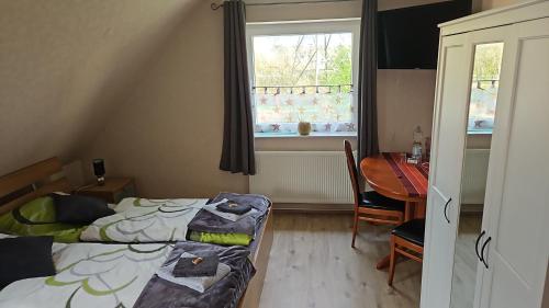 1 dormitorio con 2 camas, mesa y ventana en Möwennest im Umland Hamburgs, en Henstedt-Ulzburg