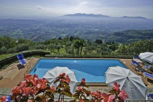 einen Pool mit Sonnenschirmen und Aussicht in der Unterkunft Ferienhaus für 12 Personen in Capannori, Toskana Provinz Lucca - b63292 in Petrognano