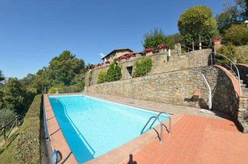 einen Pool neben einer Steinmauer in der Unterkunft Ferienhaus für 12 Personen in Capannori, Toskana Provinz Lucca - b63292 in Petrognano