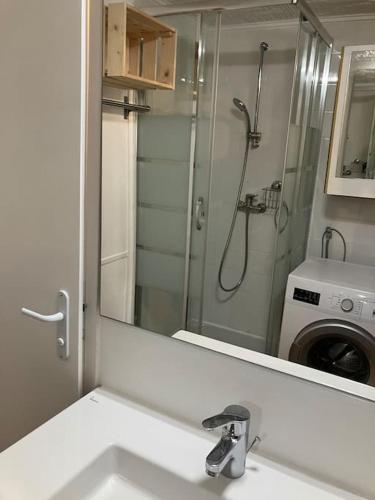 La salle de bains est pourvue d'un lavabo avec miroir et d'un lave-linge. dans l'établissement Petite maison avec piscine entre mer et montagne, à Tourrettes