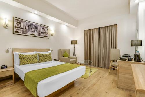 a hotel room with a large bed and a desk at Lemon Tree Premier 1, Gurugram in Gurgaon
