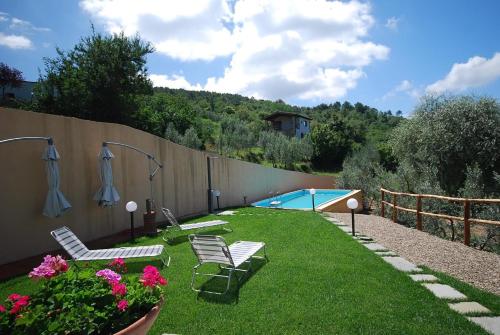 un patio trasero con sillas y una piscina en Ferienhaus mit Privatpool für 10 Personen ca 200 qm in Civitella in Val di Chiana, Toskana Provinz Arezzo, en Civitella in Val di Chiana