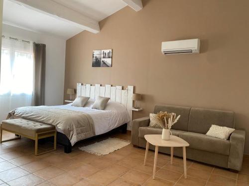a bedroom with a bed and a couch at B&B La Maison Du Castellet in Le Castellet