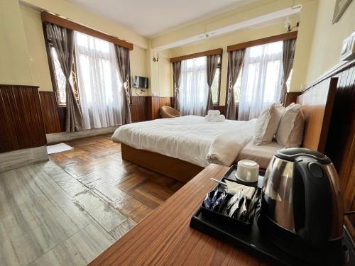 una habitación de hotel con una cama y un teléfono en una mesa en Yesheyzz Homestay, Upper Sichey, Gangtok, en Gangtok