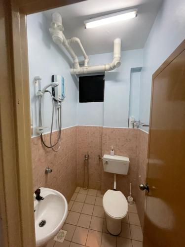 y baño con aseo, lavamanos y tuberías. en Serene Bukit Beruang Cottage 4 ROOMS FULL AIRCOND & NETFLIX by EZYROOM MELAKA, en Ayer Keroh