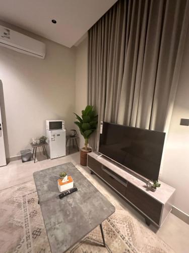 a living room with a large flat screen tv at شقة بغرفتي نوم وصالة ودورتين مياه بالعارض قرب المطار بتسجيل وصول ذاتيTwo-bedroom apartment with living room and two bathrooms in Al-Aridh near the airport with self-check-in in Riyadh