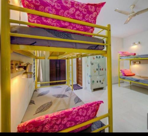a room with two bunk beds with pink sheets at White Camel companies in Hyderabad