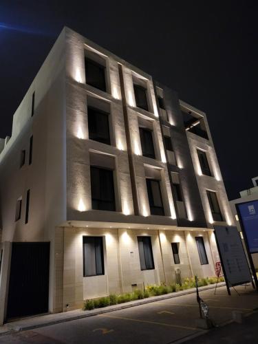 a white building with lights on the side of it at شقة بغرفتي نوم وصالة ودورتين مياه بالعارض قرب المطار بتسجيل وصول ذاتيTwo-bedroom apartment with living room and two bathrooms in Al-Aridh near the airport with self-check-in in Riyadh