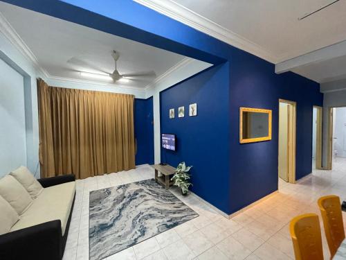 uma sala de estar com paredes azuis e um sofá em Serene Bukit Beruang Cottage 4 ROOMS FULL AIRCOND & NETFLIX by EZYROOM MELAKA em Ayer Keroh