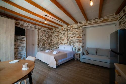 a bedroom with a bed and a couch at Epithea Suites Kythnos Keli in Kithnos