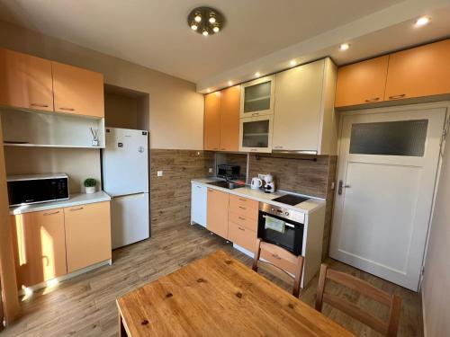 a kitchen with white appliances and wooden cabinets at Rio Sunny 2BDR Apt near NDK - Metro - non-stop paid public Parking in Sofia