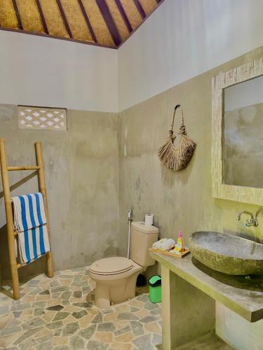 a bathroom with a toilet and a sink at Green Coco House in Amed