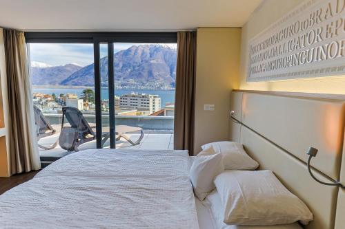 Cette chambre d'hôtel comprend deux lits et offre une vue sur les montagnes. dans l'établissement Hotel Garni Muralto, à Locarno