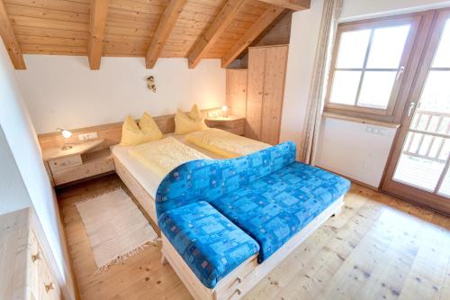 un dormitorio con un gran sofá azul en una habitación en Lavendelhof, en Appiano sulla Strada del Vino
