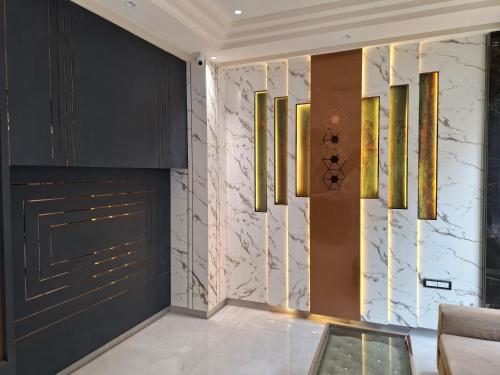 a living room with black cabinets and gold chandeliers at Hotel Golden Wings in New Delhi