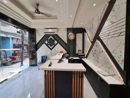a lobby with a counter with a clock on the wall at Hotel Golden Wings in New Delhi