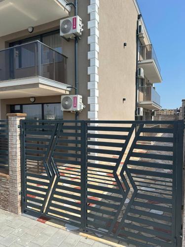 a black fence in front of a building with speakers at Studios and Apartments Pomorie in Pomorie