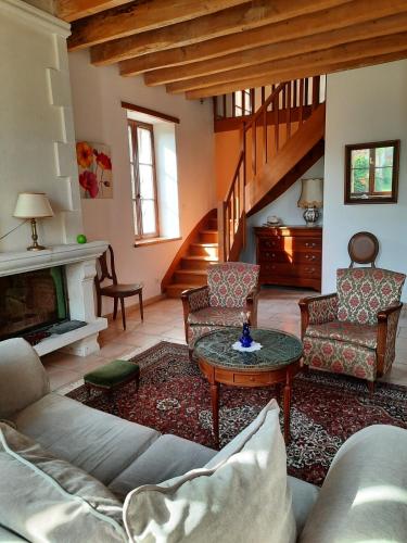 ein Wohnzimmer mit einem Sofa und einem Tisch in der Unterkunft Gîte de l'école in Pontlevoy