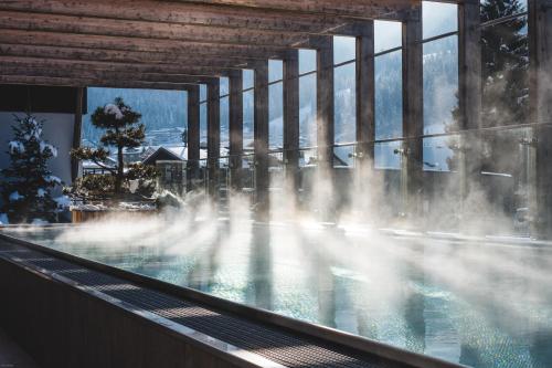 a pool with a water fountain in a building at Dips&Drops - First Bike & Ski Hub in Flachau