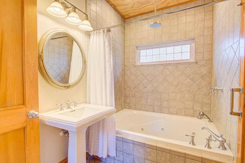 a bathroom with a tub and a sink and a mirror at IC3 The Wright Getaway Dog Friendly in Manteo