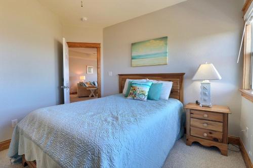 a bedroom with a blue bed and a night stand at LSC201-Gracens Sweet Retreat1 Min Drive to Beach in Nags Head