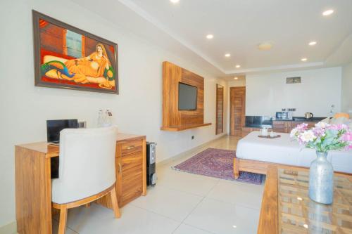 a bedroom with a bed and a desk and a vase of flowers at Perfectstayz Premium Mokshada Suites in Mussoorie