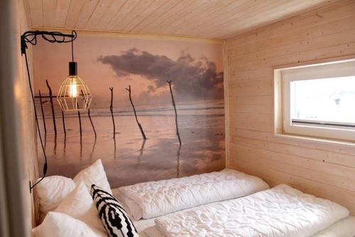 una habitación con una pared con una pintura del océano en Koje-KALLE, en Heiligenhafen