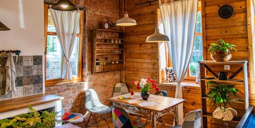 a dining room with a table and chairs at Minifaktúra Loft Apartman & Reggeliző és Ételbár in Szokolya