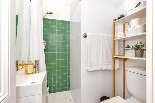 a green tiled bathroom with a toilet and a shower at 'The Cosy Corner' Classic Haven with Modern Comforts in Adelaide