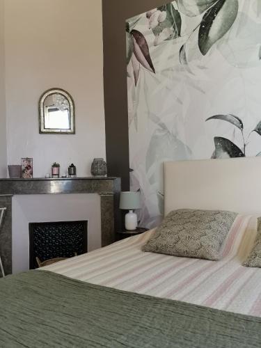 une chambre avec un lit et une cheminée dans l'établissement Le Domaine de Tini, à Violès